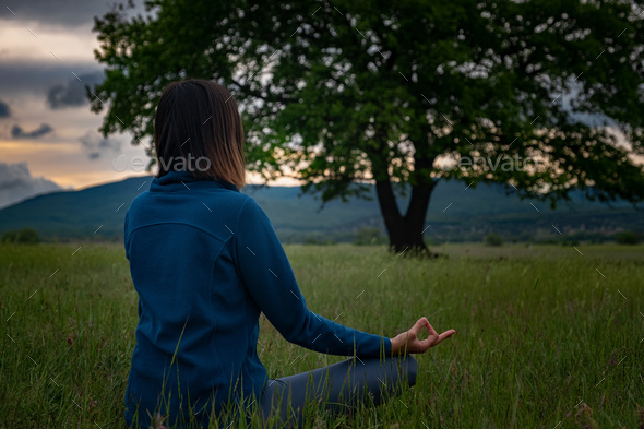 A young woman doing yoga in the field.