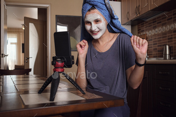 Woman sits on kitchen and Makes a mask of green clay.