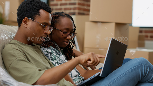 Married life partners looking at home decor inspiration on laptop