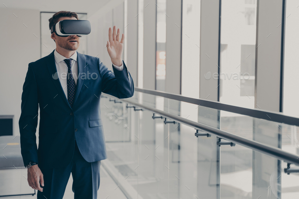 Excited office worker dressed in formal clothes managing business project through virtual reality