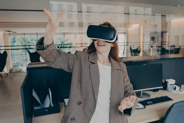 Female office worker using virtual reality headset to visualize and browse files at work