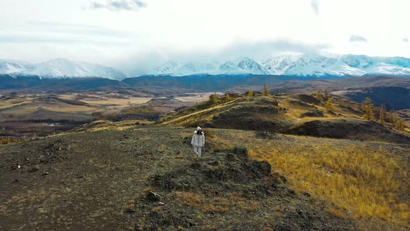 Girl Tourist in White Clothes in Mountains