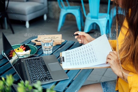 Woman numerologist working with numbers in notepad and laptop