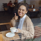 Beautiful stylish African American woman showing thumb up while working on laptop in a coffee shop - PhotoDune Item for Sale