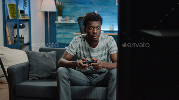 Man playing video games on tv console with controller