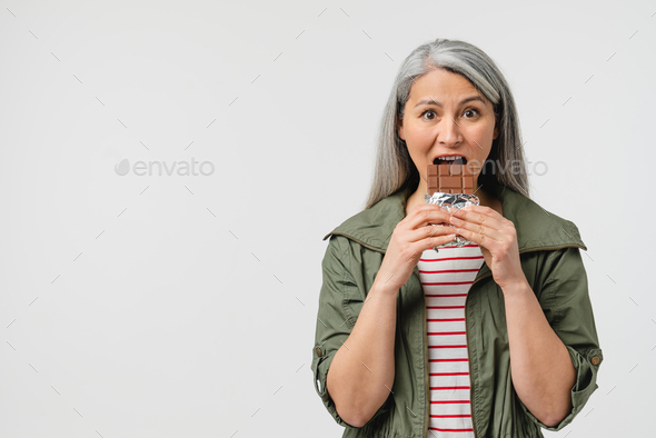 Binge eating, overeating. Unhealthy junk food. Calories and saturated fats. Mature middle-aged woman - Stock Photo - Images