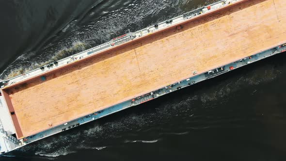 Long Brown Unloaded Freight Vessel Sails on Deep Water alt