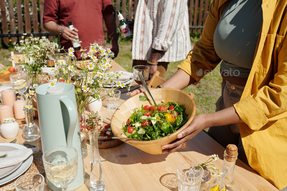 Young black woman serving table with homemade food, drinks and other stuff