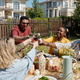 Young interracial friends with glasses of homemade wine and bottles of beer - PhotoDune Item for Sale