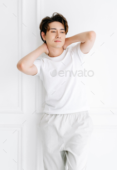 Asian man wearing casual clothes relaxing with stretching arms and hands behind head and neck