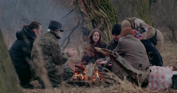 Soldier And Refugees Warming Hands At Bonfire alt