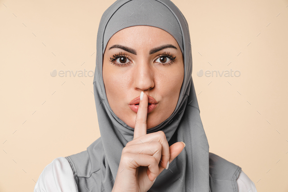 Pretty Middle eastern arabian muslim islamic young woman in grey hijab making silent gesture