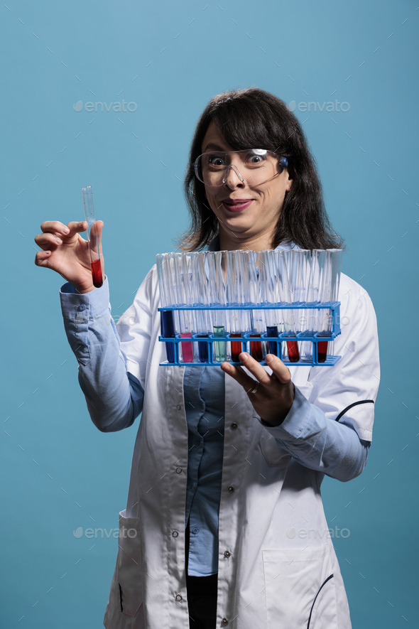 Laboratory worker expert with creepy smile having rack full of test tubes filled with liquid
