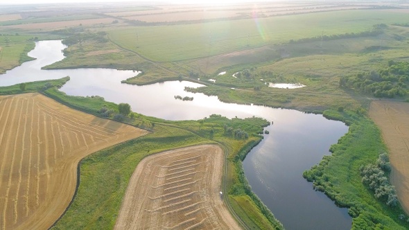 Scenic aerial view of winding river and agricultural fields alt