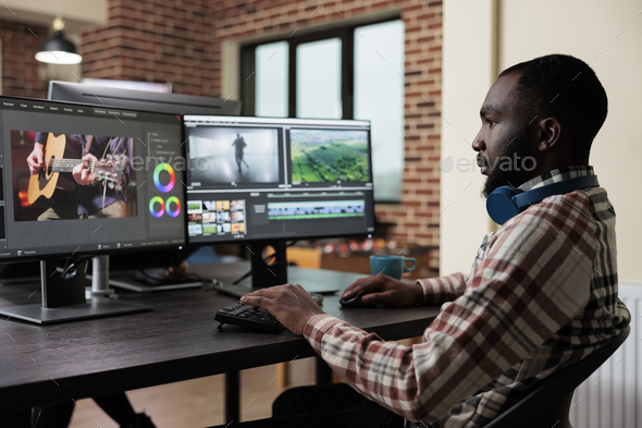 Digital footage professional editor at multi monitor workstation improving visual quality