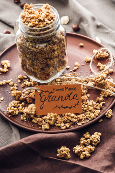homemade appetizing granola in glass jar with tag on tray