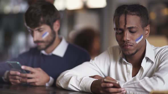 Sports Betting Football Fans Sits in a Bar During a Football Match and Using Their Smartphone alt