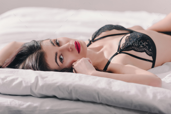 beautiful sexy girl in black lace bra lying on bed Stock Photo by  LightFieldStudios