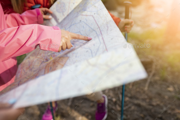 trekking woman hand pointing route on map