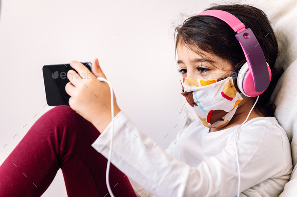 kid with headset and mask making a video call