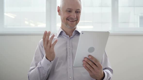 Online Video Chat on Tablet By Middle Aged Man alt