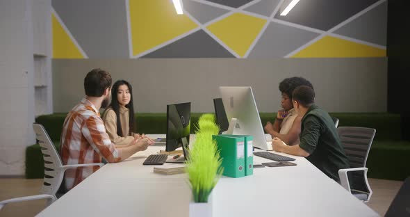Multinational People Sit at Desks Working on Computers