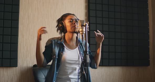 Young African American Lady Singing Song at Professional Sound Record Studio, Slow Motion alt
