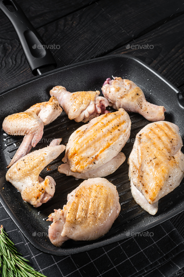 Roasted on a grill skillet chicken meat and chicken parts - drumstick, breast fillet, wing, thigh.