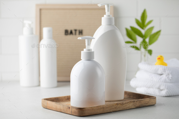 Blank plastic dispenser bottles with soap and shampoo for everyday in bathroom. Toiletries set