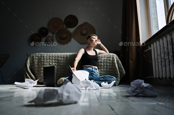 Woman professional content writer working with papers and laptop computer at home