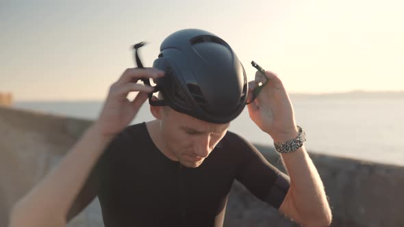 Cyclist Wearing Helmet.Cyclist In Lycra Sportswear.Triathlete Puts On Helmet Before Cycling Training alt