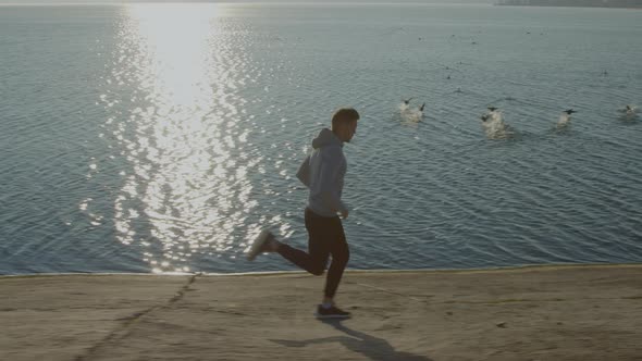 Man Is Running Near Lake with Ducks