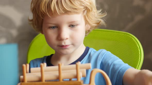 Blond Hair Boy Playing With Wooden Balk
