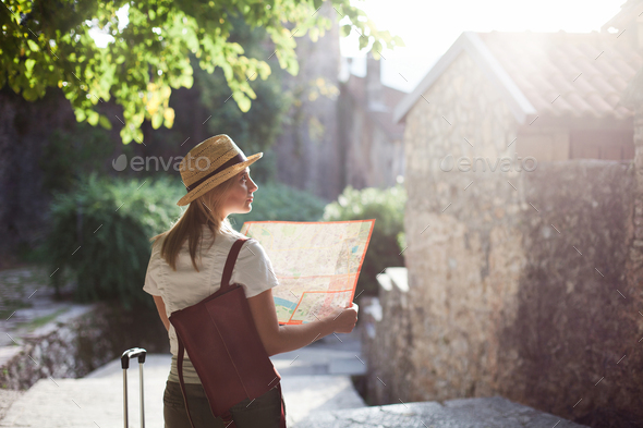 Girl traveler with city map at town street