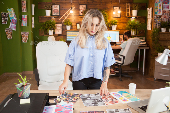 Caucasian female designer checking her interns designs