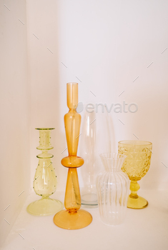 Colorful glass vases in a white shelf in a wall, home decoration.