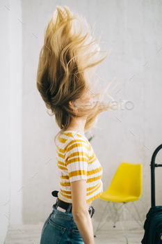 Young attractive caucasian woman shaking her blonde hair.