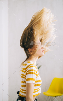 Young attractive caucasian woman shaking her blonde hair.