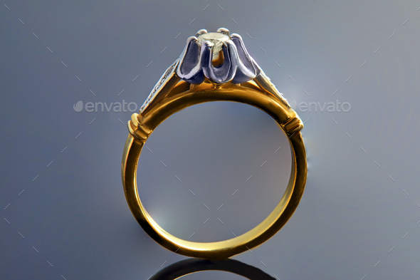 Gold ring in white and yellow gold with diamonds on a background with a gradient and reflection
