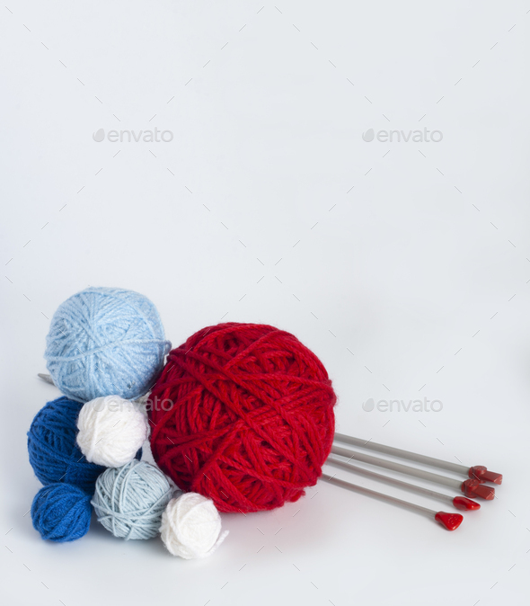 Bright knitting balls and metal knitting needles on a white background.