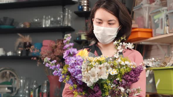 Asian Woman in Mask Arranging Bouquet. Floral Composition. Female Florist Making Modern