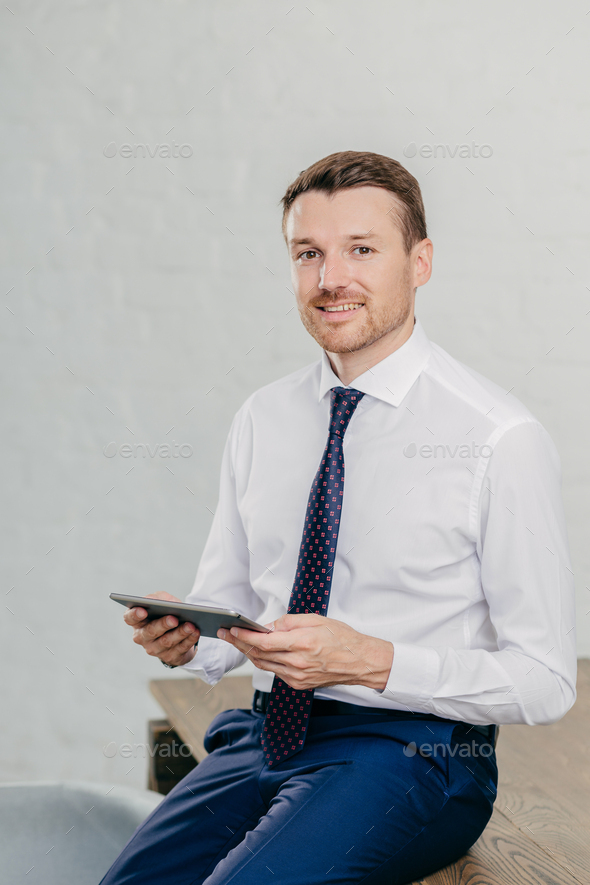 Successful owner of financial company wears elegant clothes, reads notification