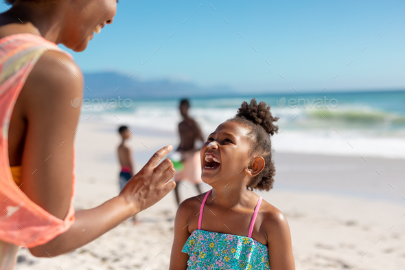 Cheerful african american mother and daughter enjoying sunny day at beach with family, copy space - Stock Photo - Images