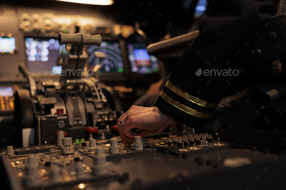 Woman aircrew switching control panel buttons on dashboard command
