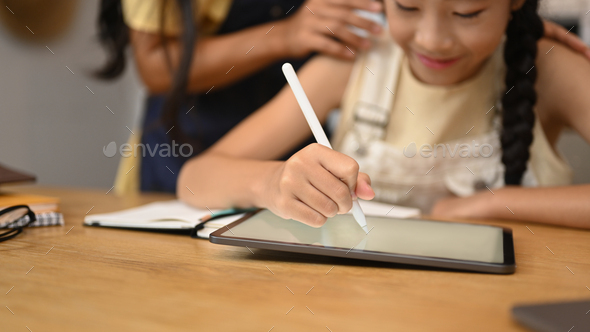 Focused asian girl using digital tablet, doing homework, studying online on web virtual class.