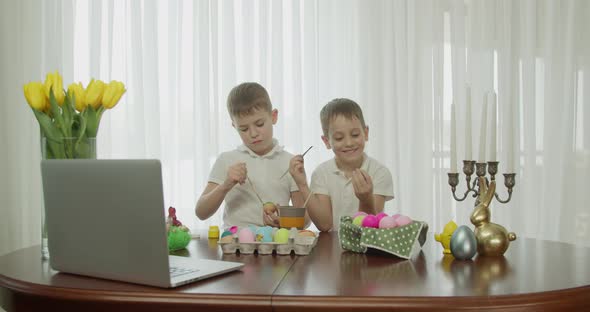 Two Boys Paint Easter Eggs and Greet Each Other alt