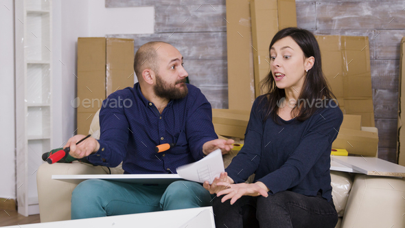 Angry girlfriend hitting boyfriend with furniture instructions