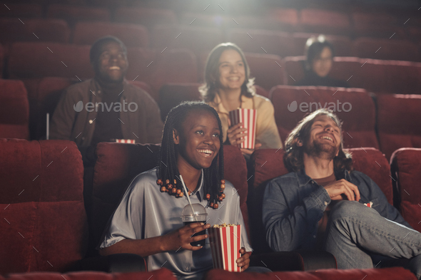 Happy friends watching movie in the cinema