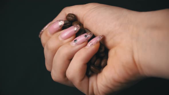 Coffee Beans are Hung Out of Female Hands alt