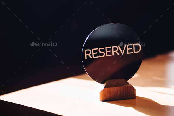 Restaurant reserved table for party. Reservation sign on wooden cafe table